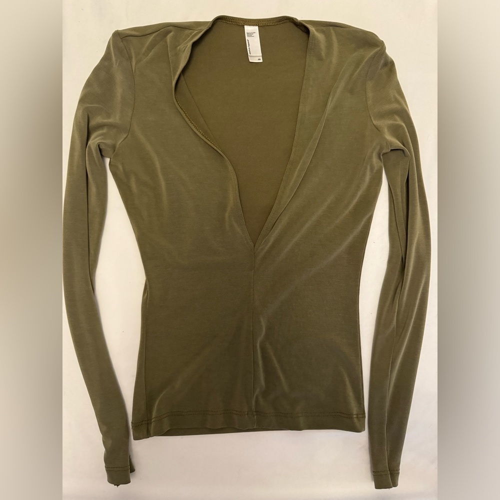 Deep V olive tone fitted long-sleeved shirt.